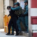 Agentes de la Guardia Civil custodian, tras el registro de su domicilio, al ciudadano marroquí seguidor de la organización yihadista Dáesh profundamente radicalizado y que quería llevar a cabo una acción terrorista para lo que buscaba posibles objetivos por la ciudad saltándose de forma habitual el confinamiento del estado de alarma y que fue detenido en 2020 en Barcelona. EFE/Alejandro García