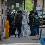 Agentes de la Guardia Civil totalmente protegidos salen de un domicilio de la calle de Josep Anselm Clavé en el distrito de Ciutat Vella de Barcelona donde detuvieron a un presunto yihadista