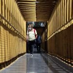 Una persona con mascarilla cruza un puente en Valencia
