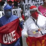 Central University teacher join students protesting education budget cuts, proposed by President Lenin Moreno to ease the economic pressure caused by the COVID-19 pandemic in Quito, Ecuador, Monday, May 11, 2020. (AP Photo/Dolores Ochoa)