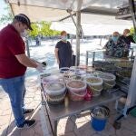 Varias personas compran en un puesto de encurtidos del mercadillo semanal