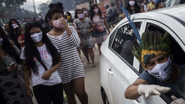 AME9921. MANAOS (BRASIL), 14/05/2020.- Ciudadanos asisten al funeral del cacique Messías Kokama, de 53 años, víctima de covid-19, en el Parque de las Tribos este jueves, en la ciudad de Manaos, Amazonas (Brasil). El cacique Messías Kokama, considerado como el principal líder indígena de la ciudad de Manaos, capital del estado brasileño de Amazonas, murió víctima del coronavirus SARS-CoV-2 y su comunidad lo despedía este jueves sin poder rendirle todos los homenajes con sus tradicionales rituales. EFE/ Raphael Alves