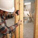 Un obrero toma medidas en una vivienda