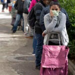 Fila de personas sin recursos que hacen cola para conseguir alimentos en la Asociación de Vecinos de Aluche, en Madrid