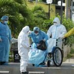 Una paciente recuperada de COVID-19 abandona este viernes el hospital, acompañada por miembros de salud pública
