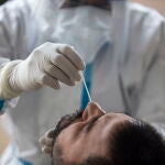 Un sanitario recoge muestras para un test PCR.