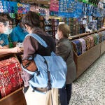 Un trabajador de un pequeño comercio atiende a dos clientes