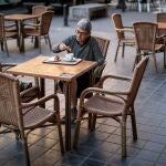Una mujer desayuna en una terraza