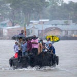Familias cruzan el río para protegerse de las lluvias torrenciales provocadas por el ciclón "Amphan" en Bangladés