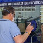 Un hombre compra lotería en una Administración