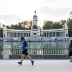 Varias personas hacen deporte a primera hora del dia junto al Estanque del Parque del Retiro de Madrid