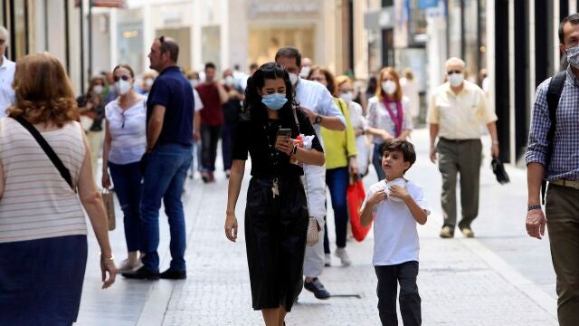 Gente con mascarillas por las calles de Sevilla