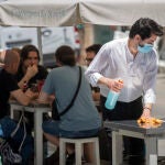 Un camarero en la terraza de un bar en Sevilla