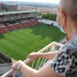 Una aficionada ataviada con mascarilla, presencia desde el balcón de su domicilio, el encuentro entre el Rayo Vallecano y el Albacete