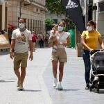 Gente con mascarillas por las calles de Sevilla