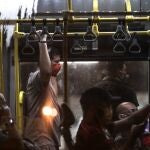 Personas con mascarilla en un autobús hoy viernes en la ciudad de Río de Janeiro