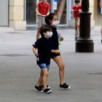 Dos niños, en la calle con mascarillas