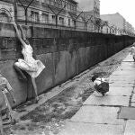 Tres niños juegan en el muro de Berlín