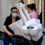Una trabajadora traslada unos maniquíes por el centro de la capital hispalense
