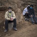 Angel Aguero, left, wearing a mask to curb the spread of the new coronavirus, waits to refill his cup with quinoa donated by a family at the Villa Maria del Triunfo district of Lima, Peru, Wednesday, June 17, 2020. The food was donated by a wealthy family and distributed in a poverty-stricken area of the capital. (AP Photo/Rodrigo Abd)
