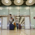 Dos jóvenes caminan por el Aeropuerto de Madrid-Barajas Adolfo Suárez durante el primer día de la nueva normalidad tras la reapertura de las fronteras comunitarias