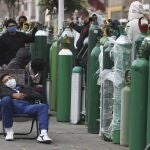 FILE - In this Monday, June 8, 2020 file photo, people wearing masks amid the COVID-19 coronavirus pandemic wait for hours, some for 10 hours, to refill their oxygen tanks at a shop in Callao, Peru. Long neglected hospitals around the world are reporting shortages of oxygen as they confront the spread of the disease. (AP Photo/Martin Mejia)