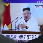 People watch a TV showing a file image of North Korean leader Kim Jong Un during a news program at the Seoul Railway Station in Seoul, South Korea, Wednesday, June 24, 2020. Kim suspended his military's plans to take unspecified retaliatory action against South Korea, state media said Wednesday, possibly slowing a pressure campaign against its rival amid stalled nuclear negotiations with the Trump administration. The Korean letters read: "Kim suspended military's plans." (AP Photo/Ahn Young-joon)