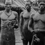 Dos esclavos sostienen unas manos amputadas ante la mirada impasible de dos agentes europeos. Una imagen tomada por Alice Seeley Harris en Baringa, Tshuapa, en mayo de 1904