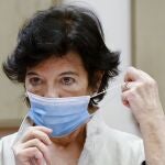 La ministra de Educación, Isabel Celaá, se coloca la mascarilla antes de comparecer ante la comisión del ramo del Congreso de los Diputados.