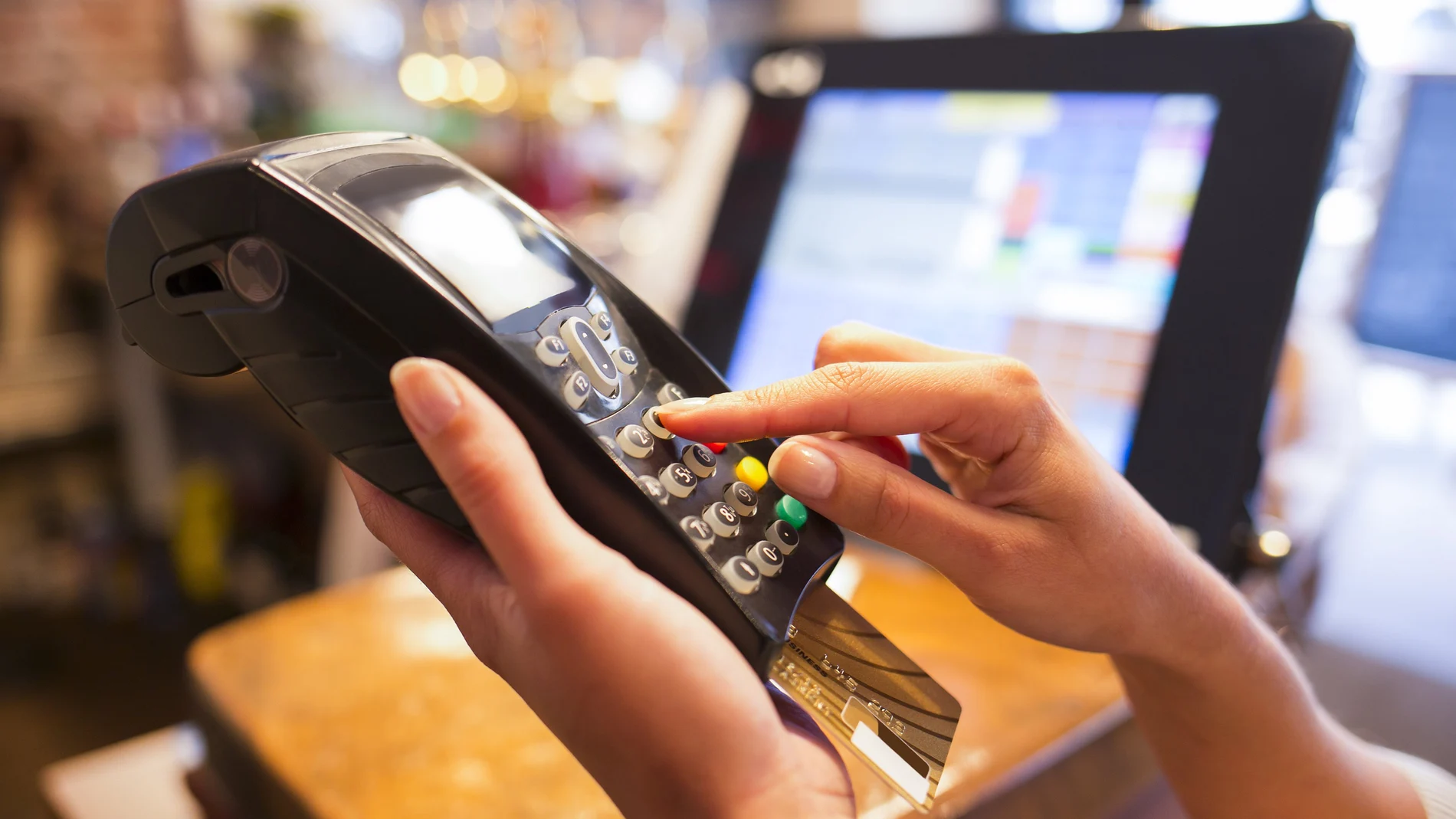 Una persona hace uso de una tarjeta de crédito en un negocio