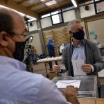 Inigo Urkullo, Basque Lehendakari or Regional President, right, wears a face mask as protection against the coronavirus while voting in a polling station during Basque regional election in the village of Durango, northern Spain, Sunday, July 12, 2020. (AP Photo/Alvaro Barrientos)