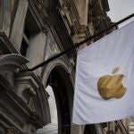 Una bandera con el símbolo de Apple decora el exterior de una tienda de la empresa en el centro de Londres