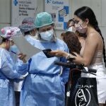 GRAFCAT9660. L'HOSPITALET (BARCELONA), 15/07/2020.- Una enfermera comprueba la cita previa de una mujer en la puerta del Centro de Atención Primaria del barrio de la Florida de L'Hospitalet (Barcelona), uno de los tres barrios de la segunda ciudad catalana en los que el Govern ha endurecido las medidas restrictivas debido a los rebrotes de covid-19. EFE/Andreu Dalmau