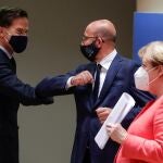 El primer ministro holandés, Mark Rutte, saluda con el codo durante la cumbre de la UE en Bruselas al presidente del Consejo Europeo, Charles Michel, ante la mirada de la canciller alemana Angela Merkel