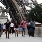 Turistas caminando junto a la torre Eiffel