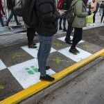 People stand on squares that help for residents to maintain a safe social distance at a bus stop La Reina borough of Santiago, Chile, Tuesday, July 28, 2020. As the Chilean government put in place a roadmap to rolling back on quarantine measures, various neighborhoods in Santiago will begin to ease on the new coronavirus lockdown on Tuesday. (AP Photo/Esteban Felix)