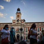 Ciudadanos caminan frente a la Real Casa de Correos, sede del Gobierno regional
