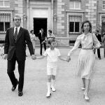 Don Juan Carlos y Doña Sofía de la mano del entonces Príncipe Felipe, durante el día de su primera comunión en Zarzuela.
