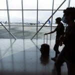 Passengers walk to their gates at Tocumen international airport which is partially restarting operations amid the COVID-19 pandemic in Panama City, Friday, Aug. 14, 2020. While most flights continue to be suspended, international connections were reactivated Friday. (AP Photo/Arnulfo Franco)