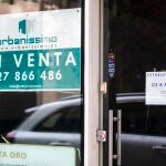 Imagen de un negocio en el que se lee un cartel de establecimiento cerrado, junto a un cartel de una inmobiliaria que anuncia la venta del local