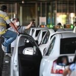 Taxistas esperan la llegada de viajeros en la parada de taxis de la Terminal 1 del Aeropuerto Adolfo Suarez