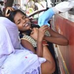 Un sanitario toma una muestra de una niña para una prueba PCR en Nueva Delhi, este jueves