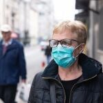 Imagen de una mujer con mascarilla andando por la calle