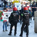 Agentes de la Ertzaintza contienen a los manifestantes que se concentran contra la participación del secretario general y diputado de Vox, Javier Ortega Smith, en una mesa informativa