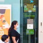 Imágenes de una sucursal bancaria de Bankia en la que se ve de fondo una de La Caixa