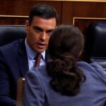 El presidente del Gobierno, Pedro Sánchez, conversa con el vicepresidente tercero, Pablo Iglesias, durante el pleno del Congreso.