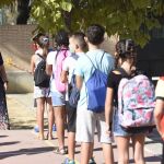 Alumnos de un colegio de Sevilla hacen cola ante una profesora