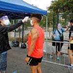Unos voluntarios toman la temperatura a unos corredores
