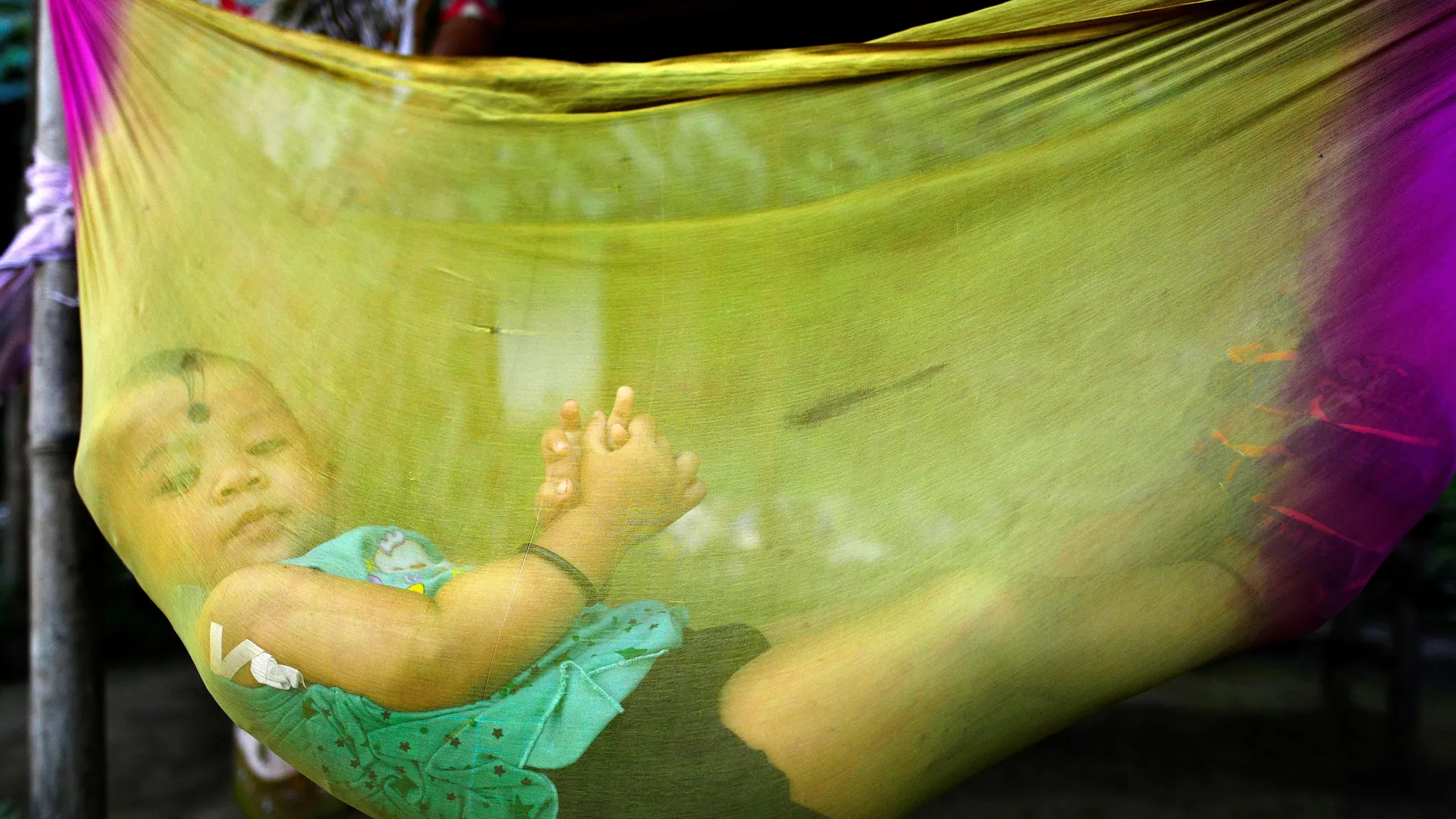 Un niño observa a través de una cuna realizada con una fina tela