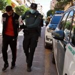 Un agente de la Guardia Civil traslada al Juzgado de Instrucción número 1 de Ontinyent, en Valencia, a uno de los diez detenidos por su supuesta participación en una violación grupal a una menor de 14 años en la localidad valenciana de l'Olleria